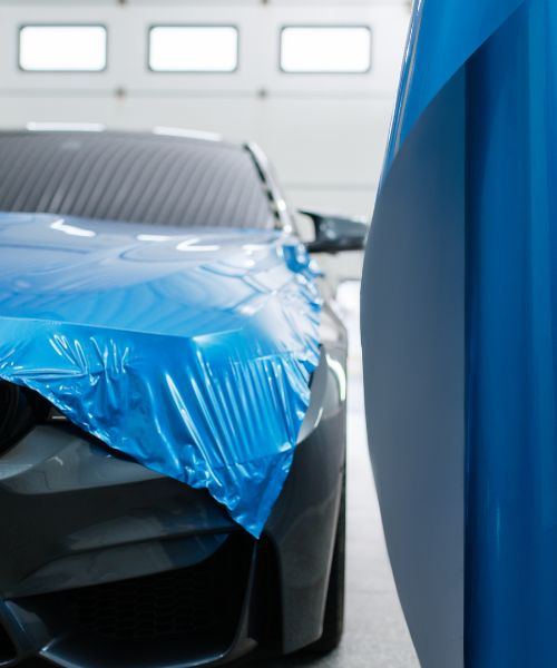 A car covered in a blue plastic wrap